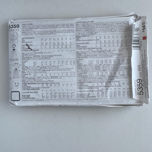 May include: A Simplicity brand sewing pattern packet, model 5359, featuring costume designs for young women. The packet includes detailed instructions and measurements for various costume pieces. The package is white with black text.