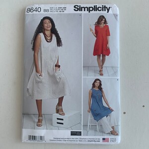 May include: Simplicity sewing pattern number 8640 for sizes 20W-28W. The pattern includes instructions for making three different dresses: a sleeveless white dress, a red dress with short sleeves, and a blue dress with short sleeves. The pattern is designed and printed in the USA.