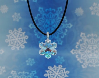 May include: A silver snowflake pendant necklace with a black cord. The snowflake is iridescent and has a blue and green hue. The necklace is on a blue background with white snowflake designs.
