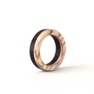 May include: A wooden ring with a dark brown outer band and a light brown inner band.