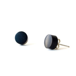 May include: A pair of black stud earrings. The earrings are round and have a smooth, matt finish.