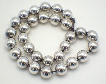 May include: A silver necklace featuring large, round beads. The necklace is crafted from sterling silver and has a simple, elegant design.