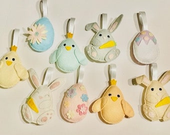 May include: Nine felt Easter decorations, including chicks, bunnies, and eggs. The ornaments are decorated with pastel colours and floral patterns.