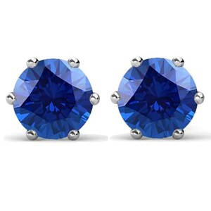 May include: A pair of silver stud earrings with a round, blue gemstone in each earring.