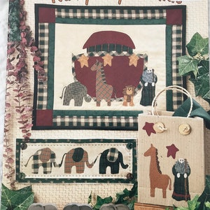 May include: A patchwork quilt with the words "Rainy Day Friends" and a design featuring an ark, giraffe, lion, and elephant. A matching tote bag and wooden elephant figurines are also visible.