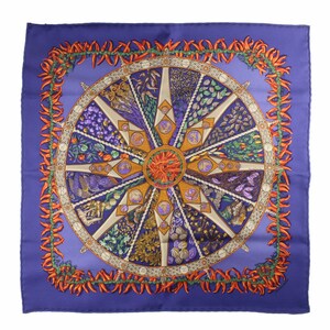 May include: A purple silk scarf with a circular design featuring a wheel with various fruits and vegetables. The wheel is surrounded by a border of orange chili peppers.