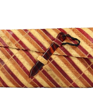 Könnte beinhalten: Eine gestreifte Clutch aus Schlangenleder mit einem braunen hornartigen Verschluss. Die Clutch hat eine Klappe, die sich umklappen lässt und mit einer schwarzen Schnur befestigt wird.