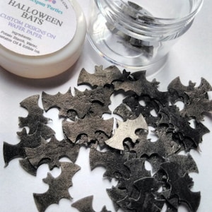May include: A clear plastic jar filled with black bat-shaped wafer paper decorations. The jar has a white label with the text "Homespun Parties HALLOWEEN BATS CUSTOM DESIGNS ON WAFER PAPER Ingredients: Potato Starch, Water, Vegetable Oil & Edible Ink"