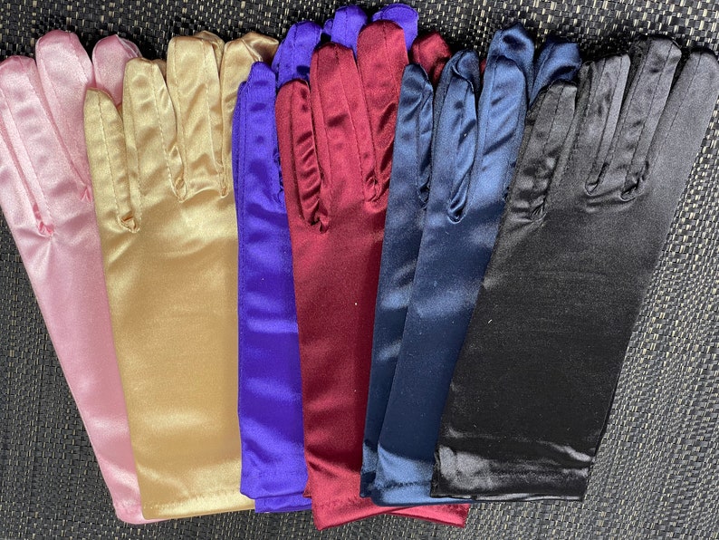 May include: Six pairs of long satin gloves in different colors: pink, gold, purple, burgundy, navy blue, and black.