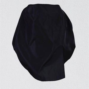 May include: A black, asymmetrical,  fabric skirt with a smooth, silky texture.