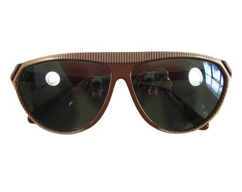 May include: Brown and white striped sunglasses with dark lenses. The sunglasses have a retro style.