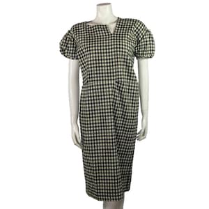 Puede incluir: Un vestido midi de cuadros vichy blanco y negro con cuello en V y mangas cortas abullonadas.