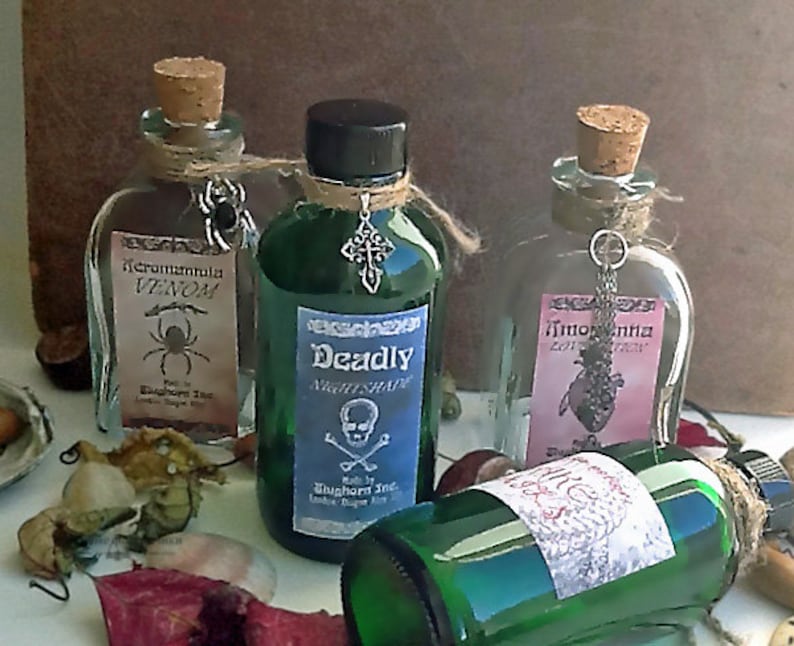 K&ouml;nnte beinhalten: Dekorative Flaschen mit Korken und Anh&auml;ngern. Die Flaschen sind mit den W&ouml;rtern "Venom", "Deadly Nightshade" und "Lotion" beschriftet. Die Flaschen enthalten gr&uuml;ne und klare Fl&uuml;ssigkeiten. Die Flaschen sind mit Schnur gebunden.