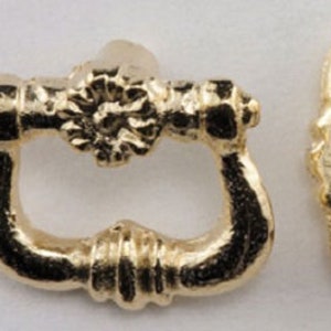 May include: Two gold-toned metal belt buckle closures. One has a decorative, ornate design. The other has a simple, rounded design.