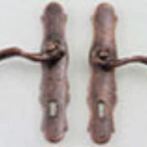 May include: Two antique-style door handles with a brown finish and a curved design. The handles have a keyhole and a lever.