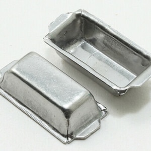 May include: Two silver metal loaf pans, one is slightly larger than the other. Both pans have a rectangular shape with slightly rounded edges.
