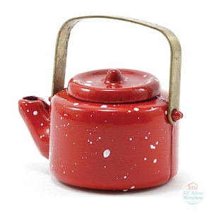 May include: A miniature red teapot with a white speckled pattern and a metallic brass-colored handle. The teapot features a round lid with a small central knob and a short spout. A small logo in the bottom right corner reads AAM All About Miniatures.