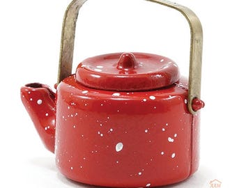 May include: A miniature red teapot with a white speckled pattern and a metallic brass-colored handle. The teapot features a round lid with a small central knob and a short spout. A small logo in the bottom right corner reads AAM All About Miniatures.