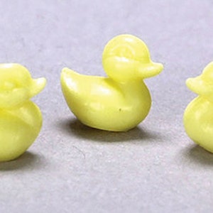 May include: Three yellow rubber duck bath toys. The ducks are small and have a glossy finish.