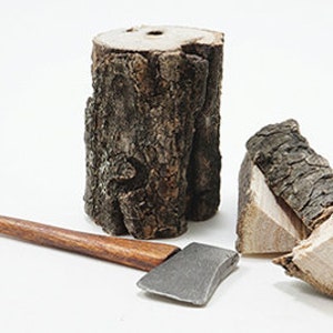 Può includere: Un'ascia di legno con manico marrone e lama argentata, un tronco grande e un mucchio di tronchi più piccoli.