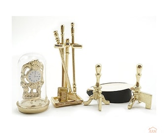 May include: A miniature gold-toned fireplace set including a clock under a glass dome, a tool stand with three implements, and two andirons. The set features intricate metalwork and a white clock face with black Roman numerals.