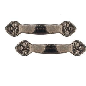 May include: Two matching metal drawer pulls with a dark, weathered finish. Each handle features a curved center bar and wide, diamond-shaped ends with a textured, hammered surface pattern and a single circular screw hole on each side.