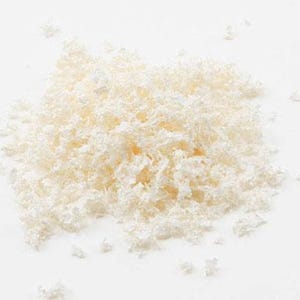 May include: A small, loose pile of white, shredded material with a crinkled, fibrous texture. The individual pieces are thin, irregular, and translucent, creating a light, airy appearance with scattered fragments extending from the main cluster.
