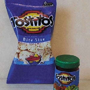 May include: A blue bag of Tostitos Bite Size tortilla chips with a red, yellow and blue logo. A small jar of Tostitos salsa with a green lid.