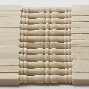 May include: A rectangular wooden dollhouse railing with a series of balusters and rectangular posts. The balusters have a turned design, and the posts are flat. The wood has a natural, unfinished appearance.