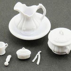 Puede incluir: Un juego de cocina blanco en miniatura para casa de muñecas, que incluye una jarra y un lavabo, una taza pequeña, una olla con tapa, una fuente y unas pinzas. El juego es de plástico.