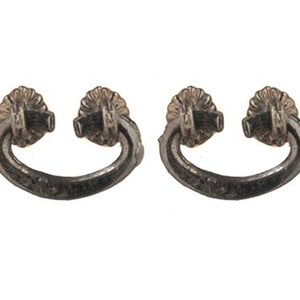May include: A pair of matching dark metallic drawer pulls, each featuring a curved, semi-circular handle suspended from two circular, fluted mounting plates. The metal has a textured, weathered finish with visible dark gray and silver tones.