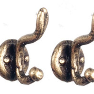 May include: Four antique-style bronze wall hooks. Each hook has a curved design with a rounded base and a small knob at the bottom. The hooks are made of metal and have a distressed finish, suggesting an aged appearance.