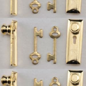May include: A collection of miniature gold-colored hardware components, including door handles, keys, and keyhole covers. The items are arranged in rows, showcasing their intricate details and vintage aesthetic. Ideal for dollhouses or craft projects.