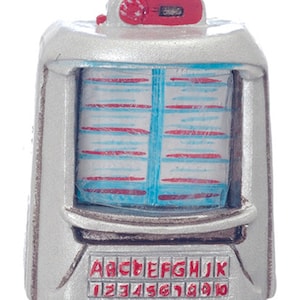May include: A miniature silver and red jukebox with a blue and red patterned front panel. The jukebox has a selection of letters and numbers on the front.