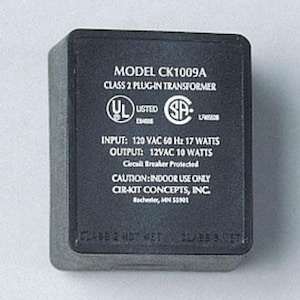 May include: A black Class 2 plug-in transformer with white text. The text includes the model number, electrical specifications, and safety certifications. The transformer is designed for indoor use.