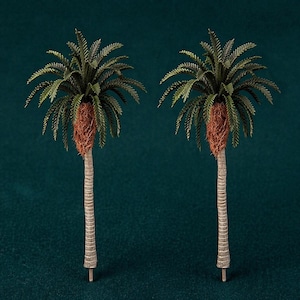 May include: Two miniature palm trees with green fronds, brown fibrous trunks, and textured gray stems. The trees are set against a dark teal background, creating a tropical theme. The detailed craftsmanship highlights the natural aesthetic of the miniature trees.