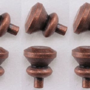 May include: Six antique copper cabinet knobs with a diamond-shaped top and a round base.