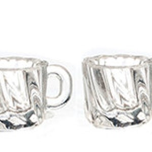 May include: Four clear glass mugs with a textured, swirled design. Each mug has a small handle and a square shape with a scalloped rim. The mugs are arranged in a row against a white background.
