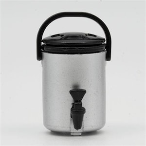 May include: A miniature silver-colored beverage dispenser with a cylindrical body, a black lid, a black carrying handle, and a small black spigot attached to the front. The item features a smooth metallic finish and a simple, functional design.