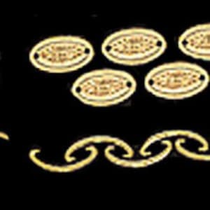 May include: A collection of gold-toned jewelry components including a cluster of small eye pins, five oval-shaped charms with central textured detailing and side holes, and a single curved chain link segment arranged on a solid black background.