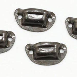 May include: Four small, dark metallic drawer pulls with a curved, semi-circular base and a central rectangular handle section. Each pull features two circular screw holes on the sides for attachment, finished in a smooth, polished gunmetal gray.