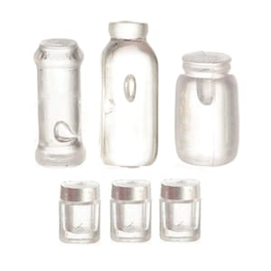 May include: A collection of six miniature clear plastic containers consisting of three larger vessels of varying shapes and three smaller cylindrical jars with silver-colored lids, all featuring a smooth, translucent finish and simple structural designs.