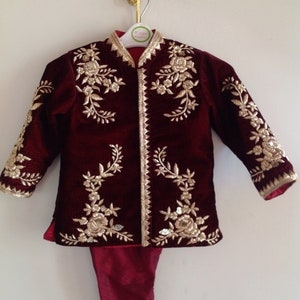 May include: A maroon velvet jacket with gold embroidery and matching pants. The jacket has a mandarin collar and a button closure.