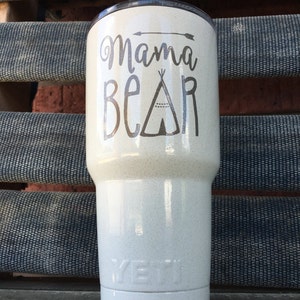 May include: White Yeti tumbler with a black and white design that says "Mama Bear" with a small arrow and a teepee graphic.