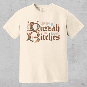 huzzah bitches funny medieval meme graphic tee on a comfort color t-shirt available in plus sizes and gender neutral