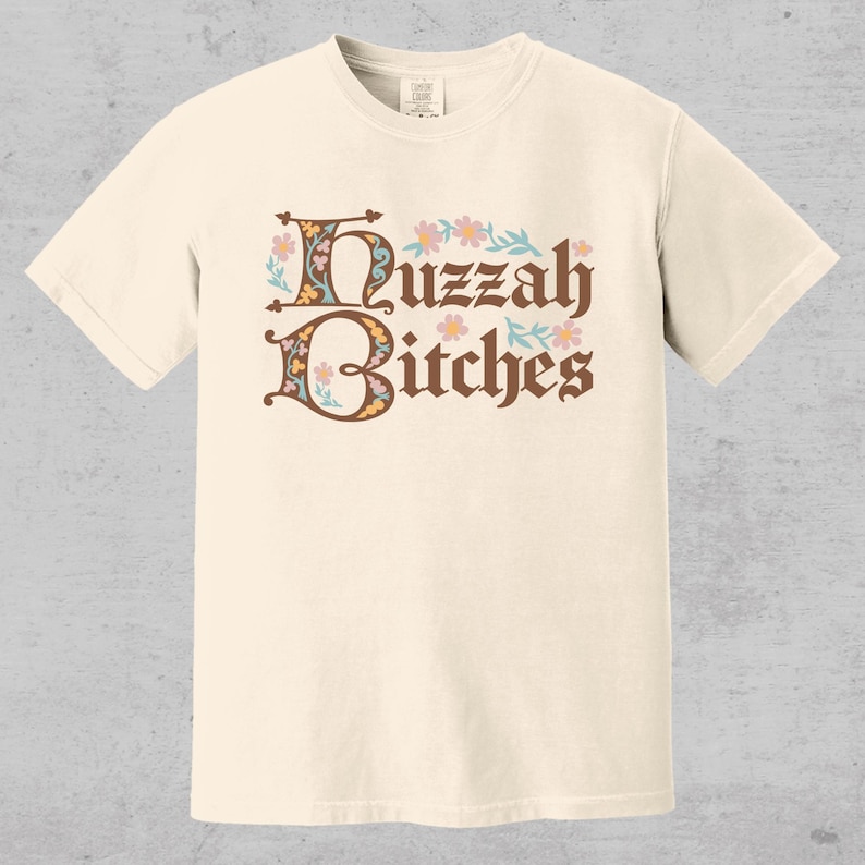 huzzah bitches funny medieval meme graphic tee on a comfort color t-shirt available in plus sizes and gender neutral