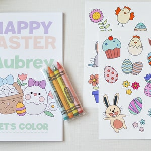 Puede incluir: Un libro para colorear de Feliz Pascua con el nombre Aubrey en la portada. El libro presenta una cesta de huevos y un pollito con un lazo. El libro viene con un paquete de crayones y dos hojas de pegatinas con im&aacute;genes de tem&aacute;tica pascual.