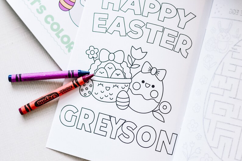 Puede incluir: Una p&aacute;gina para colorear en blanco y negro con el texto "Happy Easter Greyson". La p&aacute;gina presenta una cesta de huevos con una cara linda y un solo huevo con un lazo y una cara linda. Dos l&aacute;pices de colores est&aacute;n en la p&aacute;gina.
