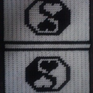 May include: Two black and white plastic canvas coasters with a stylized yin yang symbol in the center.