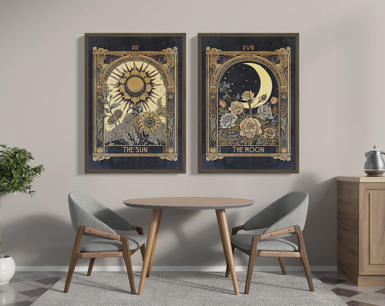 May include: Two framed prints with gold accents depicting tarot cards. The left print shows a sun with a face and rays, with the text "The Sun" below. The right print shows a crescent moon with a face and flowers, with the text "The Moon" below.
